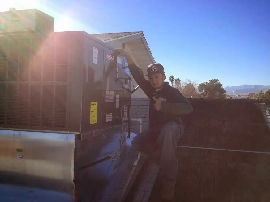 HVAC technician performing AC Tune-Up on a rooftop unit in Greenfield